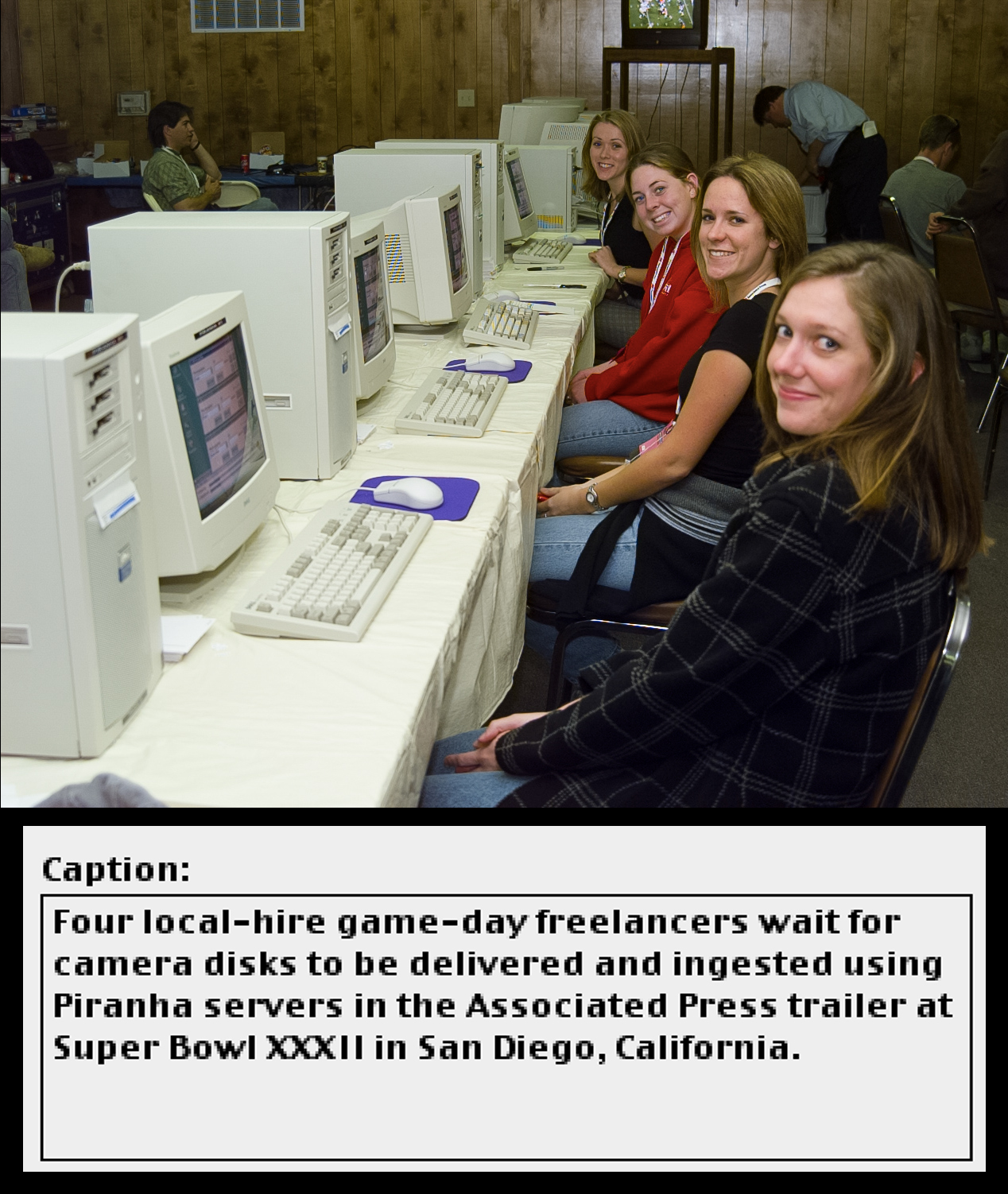 Four women sit in front of computers